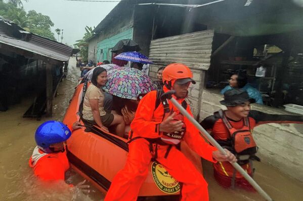 Спасатели на резиновой лодке эвакуируют жителей из затопленного дома в Индонезии. - Sputnik Армения
