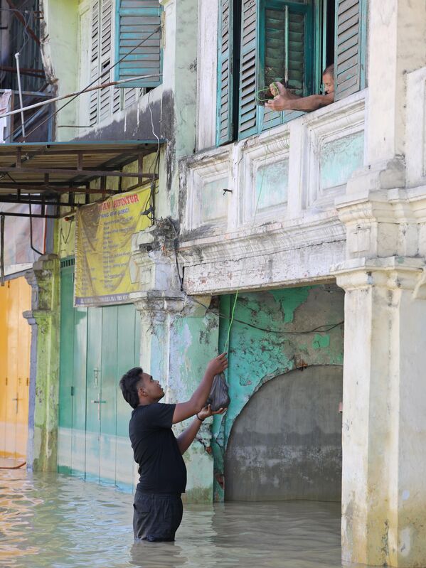 Волонтер доставляет гуманитарную помощь жителю, оказавшемуся в затопленном районе Остров Суматра - Sputnik Армения