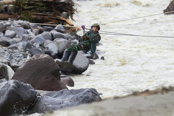 Солдат пересекает реку во время поисковой операции по спасению жертв наводнения в Танах-ДатареЗападная Суматра, Индонезия - Sputnik Армения