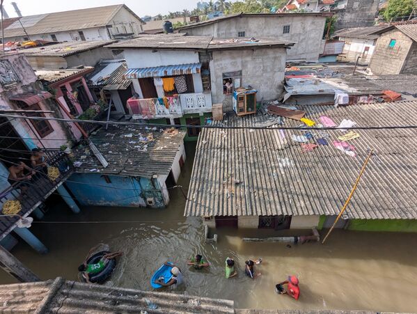 Жители плывут сквозь затопленные водой дома, а другие укрываются на верхних этажахКоломбо, Шри-Ланка - Sputnik Армения