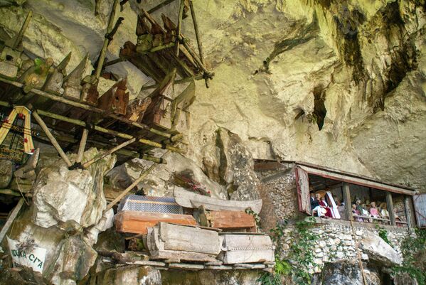 Подвесные гробы и балкон с тау-тау, изображениями умерших, в погребальной пещере в Лонде в Тана ТораджаОстров Сулавеси, Индонезия - Sputnik Армения