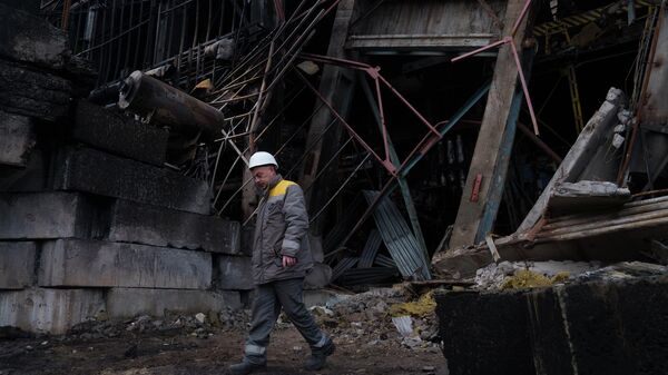 Рабочий у разрушенного производственного цеха электростанции ДТЭК (10 декабря 2025). Украина - Sputnik Армения