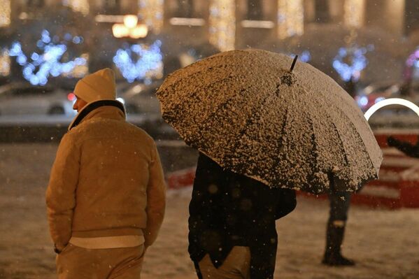 Աբովյան փողոցի լույսերը մշուշվում են առաջին ձյան փափուկ պարի մեջ՝ սովորական խցանումը վերածելով տոնական զարդարանքի։ - Sputnik Արմենիա