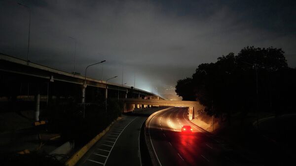 Автомобиль едет по затемнённой автомагистрали рядом с фортом Тиуна, главным военным гарнизоном в Каракасе (3 января 2026). Венесуэла - Sputnik Армения