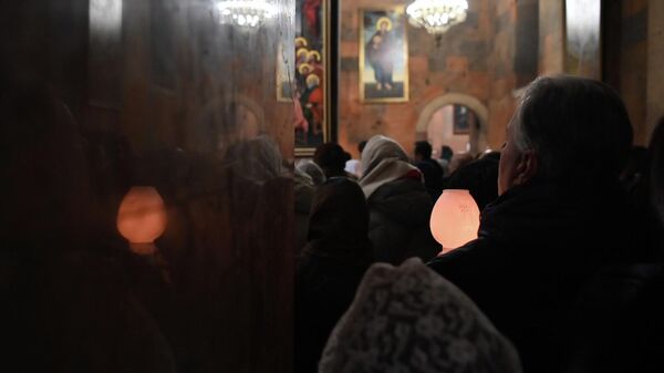 Верующие с лампадками на праздничной вечерне в церкви Сурб Саркис (5 января 2026). Еревaн - Sputnik Армения