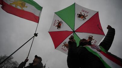 Протестующие с флагами Шаханшахского Государства Иран во время демонстрации перед зданием парламента в Лондоне (13 января 2026). Великобритания