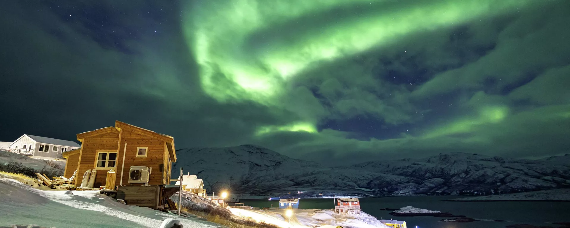 Северное сияние освещает небо над домами в Каписиллите, Гренландия - Sputnik Արմենիա, 1920, 30.01.2026