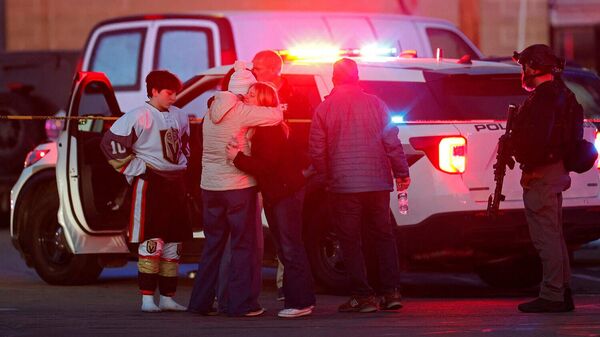 Люди у полицейского автомобиля возле крытого ледового катка Dennis M Lynch Arena после стрельбы в городе Паутакет (16 февраля 2026). Род-Айленд - Sputnik Армения