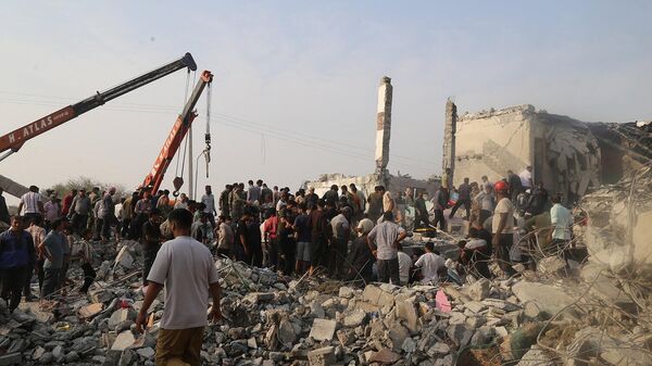 Граждане и спасатели на месте разрушенного после израильского удара школе на юге Ирана (28 февраля 2026). Минаб - Sputnik Армения