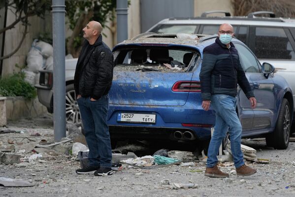 Жители осматривают место разрушенного отеля, пострадавшего от израильского авиаудара в Хазмие - Sputnik Армения