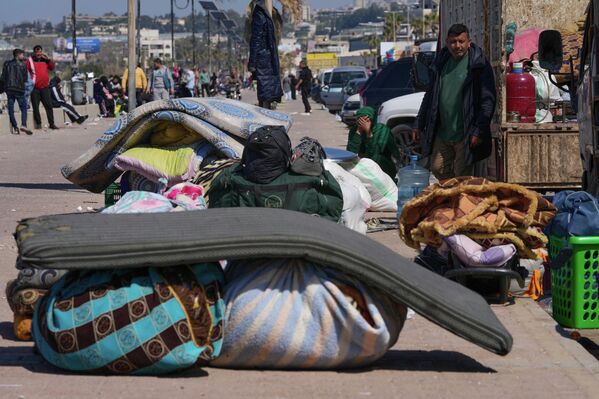 Перемещенные лица, спасающиеся от израильских авиаударов на юге Ливана, сидят рядом со своими вещами на набережной в южном портовом городе Сидон - Sputnik Армения