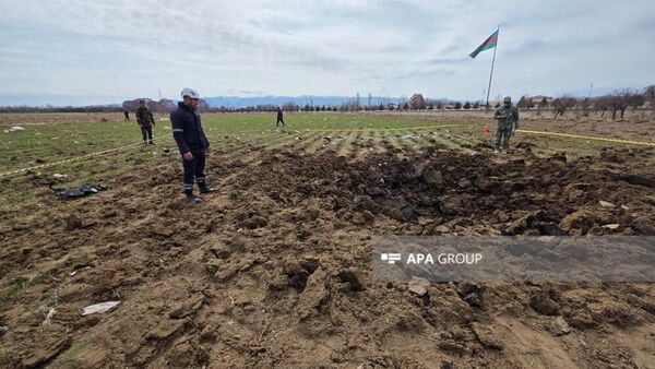 Сотрудники правоохранительных органов на месте падения иранского беспилотника недалеко от здания школы в селе Шекерабад (5 марта 2026). Нахиджеван - Sputnik Արմենիա