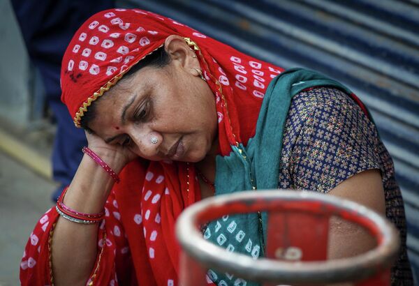 Женщина рядом с пустым баллоном со сжиженным газомИндия - Sputnik Армения