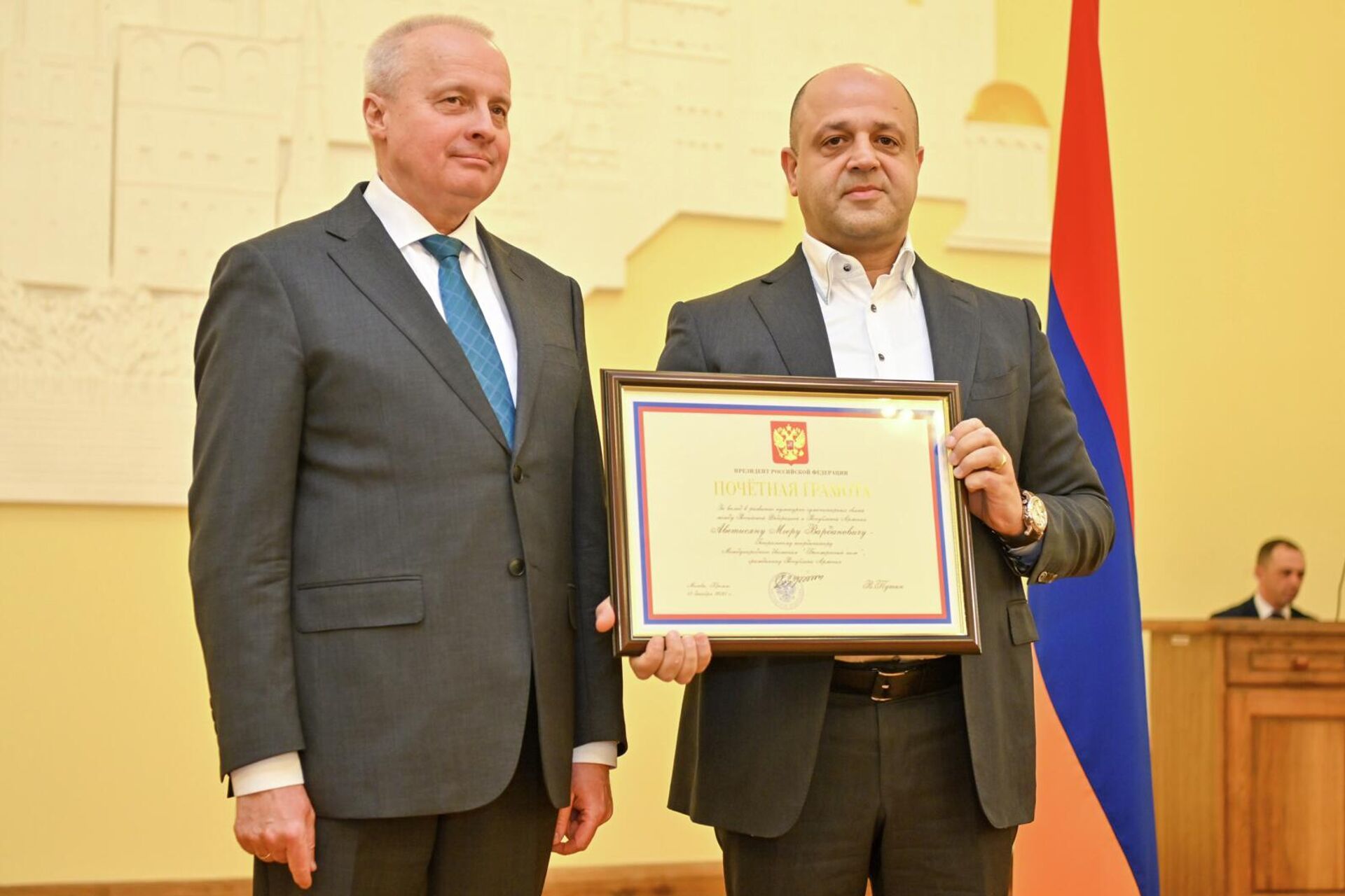 Посол РФ Сергей Копыркин вручает почетную грамоту президента России за заслуги в укреплении дружбы и сотрудничества между двумя странами генкоординатору Международного движения Бессмертный полк Мгеру Аветисяну на торжественной церемонии вручения гос.наград и благодарностей (26 марта 2026). Еревaн - Sputnik Армения, 1920, 26.03.2026