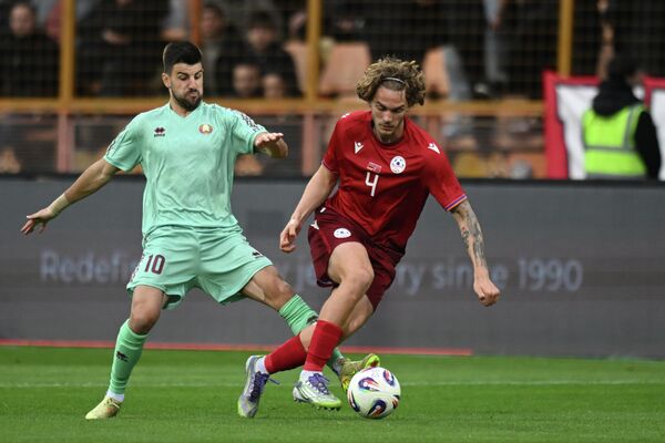 Борьба за мяч между Георгием Арутюняном и Валерием Громыко во время товарищеского матча по футболу между сборными Армении и Беларуси - Sputnik Армения