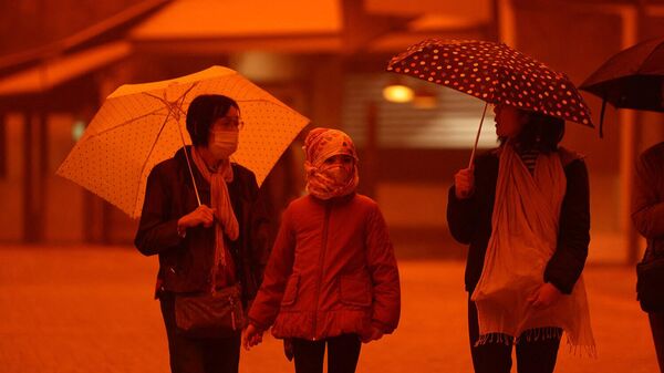 Люди в масках во время песчаной бури на острове Крит (1 апреля 2026). Ираклион - Sputnik Армения