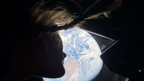 Астронавт НАСА Кристина Кох, специалист миссии Артемида II, смотрит на Землю из кабины космического корабля Орион - Sputnik Армения