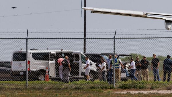 Закованные в наручники мигранты садятся в транспортный фургон после выхода из самолета в международном аэропорту Вэлли (31 августа 2025). Харлинген - Sputnik Армения
