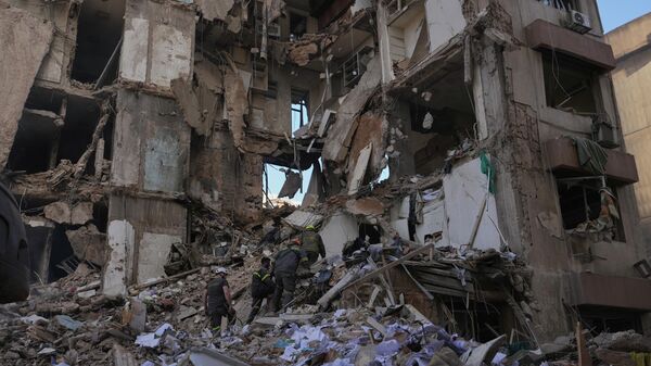 Сотрудники гражданской обороны ищут жертв в обломках здания, разрушенного израильским авиаударом днем ​​ранее в центре Бейрута (9 апреля 2026). Ливан - Sputnik Армения