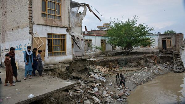 Жители осматривают здание, частично обрушившееся в результате сильного наводнения в Джелалабаде (4 апреля 2026). Афганистан - Sputnik Армения