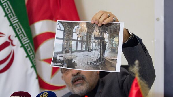 Посол Ирана Мир Масуд Хоссейниан демонстрирует фотографии повреждений исторического дворца Голестан в Тегеране, объекта Всемирного наследия ЮНЕСКО (12 марта 2026). Тунис - Sputnik Армения