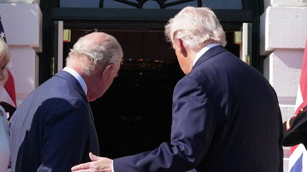 Президент США Дональд Трамп дотрагивается до плеча короля Великобритании Карла III, приглашая войти в Белый дом (27 апреля 2026). Вашингтон - Sputnik Армения
