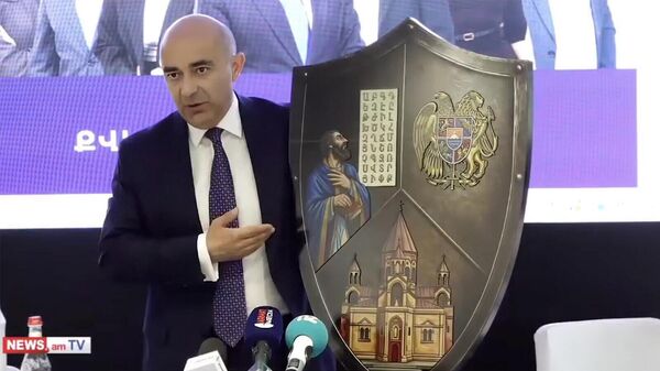 Лидер партии Просвещённая Армения Эдмон Марукян продемонстрировал журналистам щит, на котором изображены герб Армении, основатель армянского алфавита Маштоц и Кафедральный собор в Эчмиадзине - Sputnik Армения