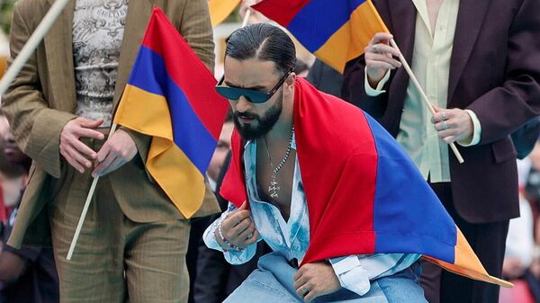 Участник из Армении на песенном конкурсе Евровидение Симон проходит по бирюзовой дорожке во время официального открытия недели Конкурса (10 мая 2026). Вена - Sputnik Армения