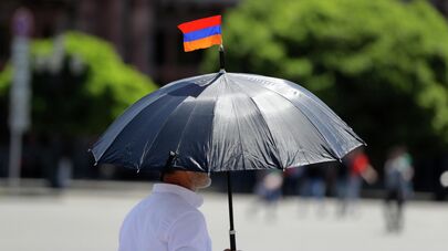 Мужчина с флажком Армении на зонтике