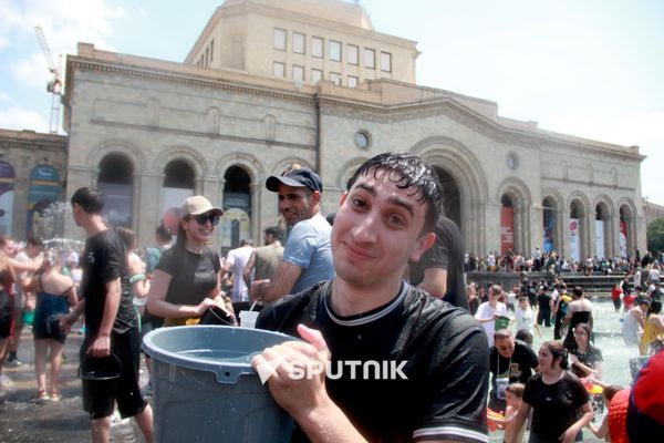Молодой человек явно готовится опрокинуть ведро с водой на фотографа Sputnik Армения - Sputnik Армения