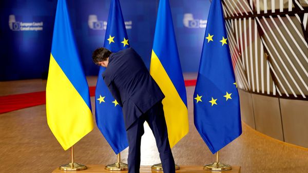 Сотрудник протокола поправляет флаги ЕС и Украины в здании Европейского совета - Sputnik Армения