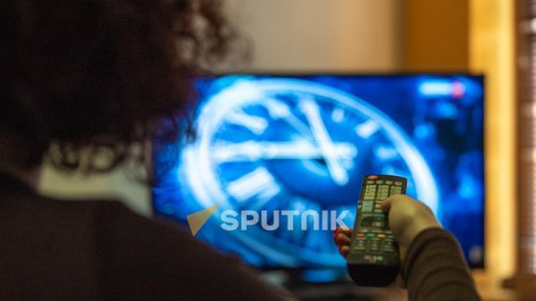 Молодая женщина переключает телеканалы - Sputnik Армения