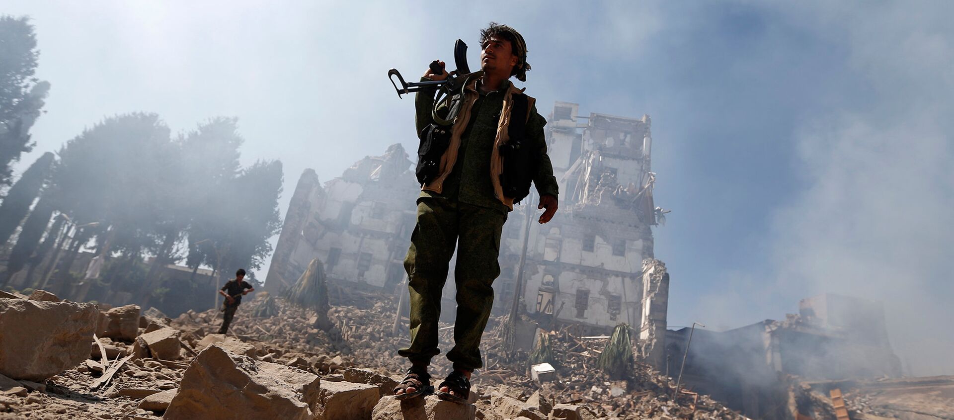 Боевики повстанцев хуситы осматривают повреждения после нанесенного воздушного удара коалицией, возглавляемой Саудовской Аравией по президентскому дворцу (15 декабря 2017). Сана, Йемен - Sputnik Армения, 1920, 24.07.2018