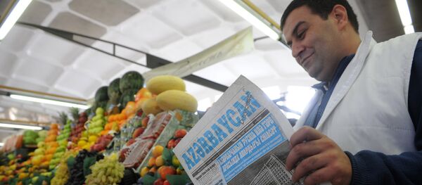 Продавец овощей и фруктов читает газету на Дорогомиловском рынке в Москве. - Sputnik Армения