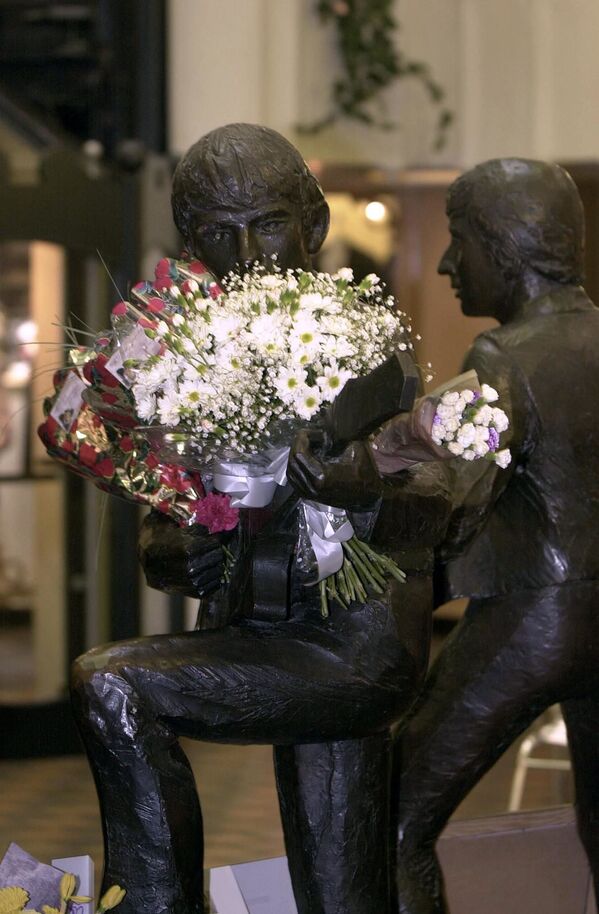 Цветы в руках статуи Джорджа Харрисона возле клуба Cavern в Ливерпуле, Великобритания. - Sputnik Армения