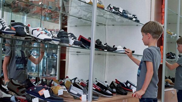 Мальчик выбирает обувь в магазине - Sputnik Армения