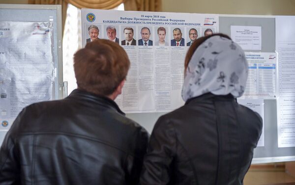 Избиратели последний раз изучают кандидатов в президенты России 2018 на избирательном участке No8031, Гюмри - Sputnik Армения