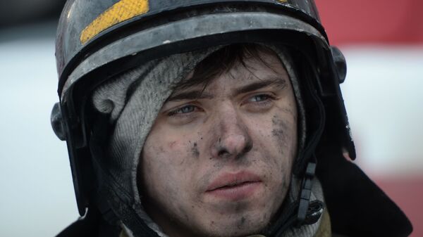 Сотрудник пожарной охраны МЧС во время тушения пожара в торговом центре «Зимняя вишня» в Кемерово  - Sputnik Армения