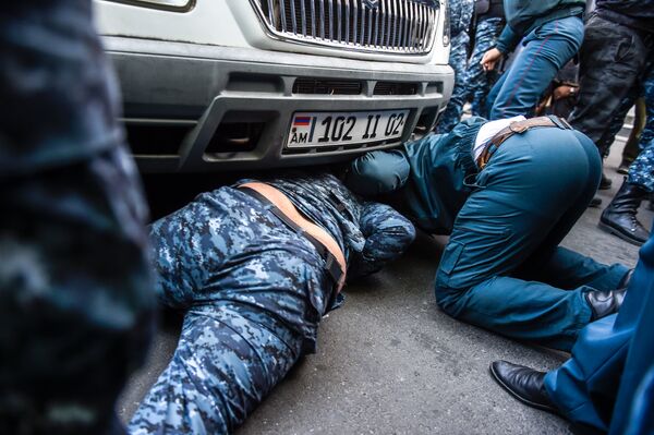 Полицейские пытаются вытащить активиста из-под автомобиля полиции Полицейские пытаются вытащить активиста из-под автомобиля полиции - Sputnik Армения