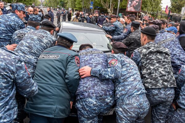 Полицейские выводят автомобиль с проезжей части, которая парализовала движение на проспекте Маштоца (21 апреля 2018). Ереван - Sputnik Армения