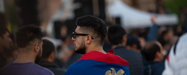 Герб Армении, изображенный на флаге Армении, обернутом гражданином Армении. Герб Армении, изображенный на флаге Армении, обернутом гражданином Армении. - Sputnik Армения