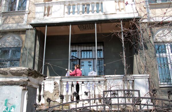Центр города. Женщина развешивает белье на балконе старинной усадьбы. - Sputnik Армения