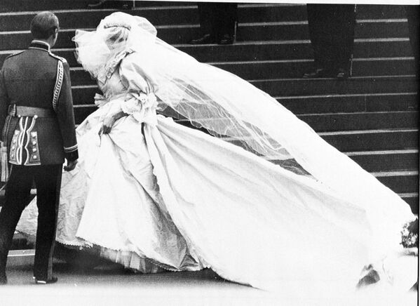 Լեդի Դիանա Սփենսերը՝ հարսանեկան զգեստով, Սուրբ Պողոսի տաճարի աստիճանների վրա հարսանեկան արարողության ճանապարհին։ Ձախից՝ անհայտ մարդ (1981թ-ի հուլիսի 29)։ Լոնդոն, Մեծ Բրիտանիա։ - Sputnik Արմենիա