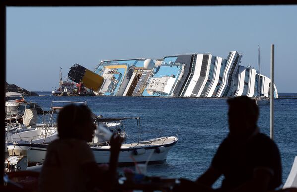 Круизный лайнер Costa Concordia, управляемый подразделением Costa Cruises компании Carnival Corp, перевернулся у острова Джильо после столкновения со скалами в пятницу, 13 января 2012 года - Sputnik Армения