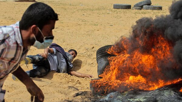 Палестинские протестующие сжигают шины во время столкновений с израильской армией вблизи границы с Израилем, к востоку от Рафаха в южной части сектора Газа в пятницу, 13 апреля 2018 года. - Sputnik Армения