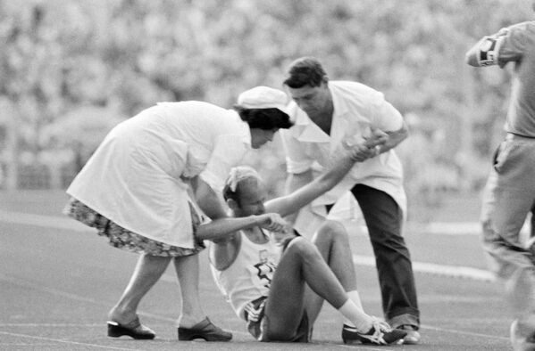 Врачи оказывают помощь легкоатлету, получившему травму во время соревнований. XXII летние Олимпийские игры в Москве, 1980 год - Sputnik Армения