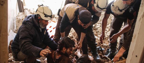 Члены сирийских добровольцев гражданской обороны, также известных как белые каски, извлекают жертву из обломков его дома (8 апреля 2017). Дараа, Сирия - Sputnik Армения