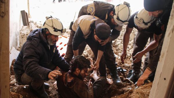 Члены сирийских добровольцев гражданской обороны, также известных как белые каски, извлекают жертву из обломков его дома (8 апреля 2017). Дараа, Сирия - Sputnik Армения