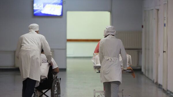 Сотрудники медучреждения транспортируют пациентов - Sputnik Армения