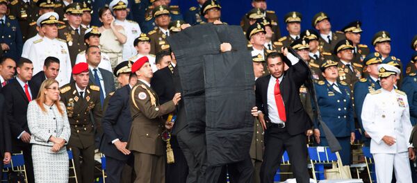 Сотрудники службы безопасности во время покушения на президента Венесуэлы Николаса Мадуро 4 августа 2018 г Сотрудники службы безопасности во время покушения на президента Венесуэлы Николаса Мадуро 4 августа 2018 г - Sputnik Армения